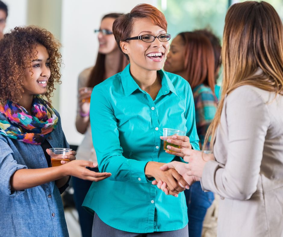 A mum and female teacher shaking hands at a school open day