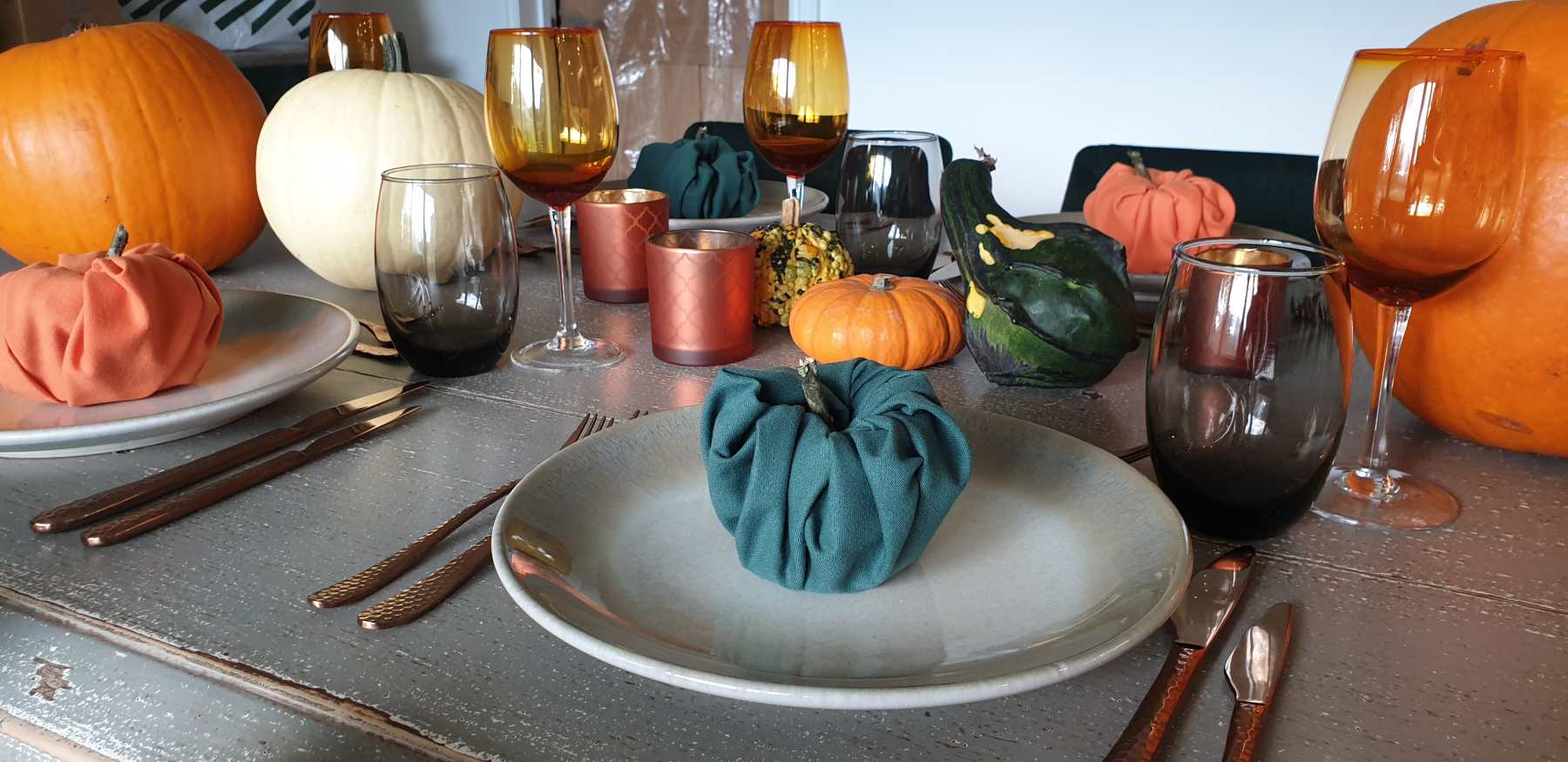 Table setting for Halloween themed events, with napkins shaped as pumpkins