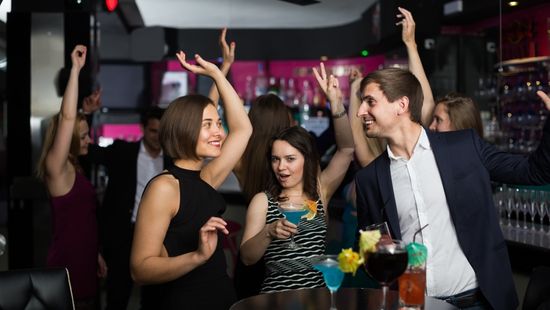 A group of people waving their arms at a corporate event