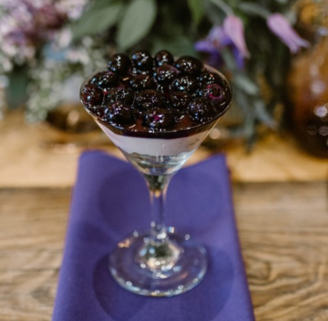 
A blueberry topped dessert in a Martini glass.