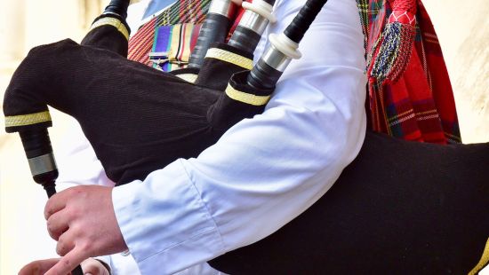 Bagpiper in traditional Scottish dress.