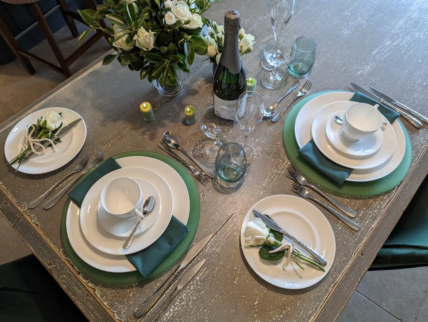 A place setting at a table for a Valentine's dinner at home in a fresh green and white theme.