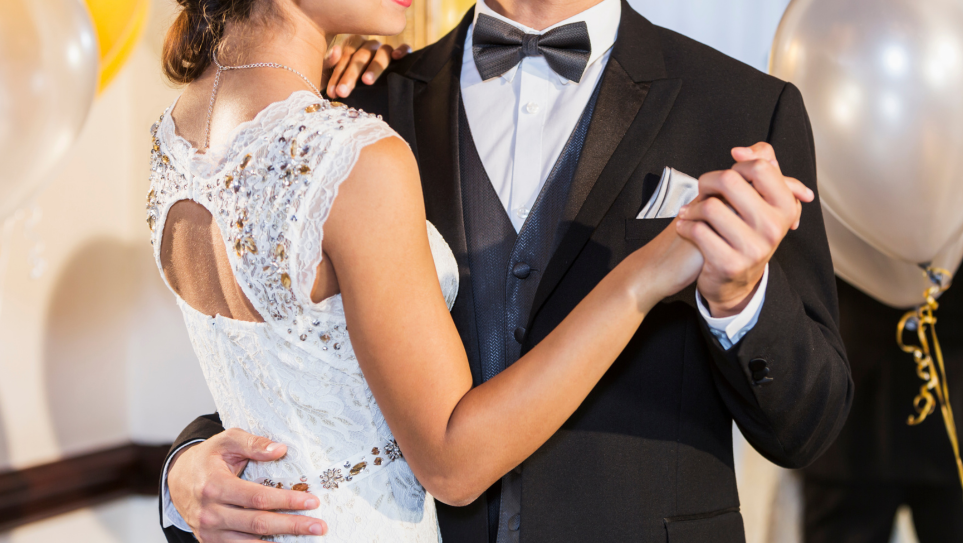 A young couple in evening wear in dance hold.