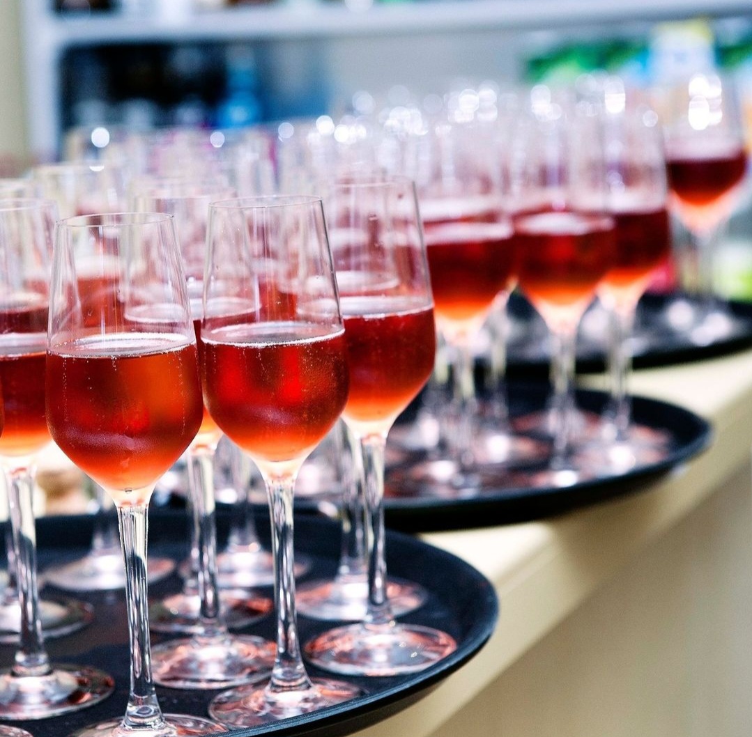 Trays full of champagne flutes with red Bellini cocktails.
