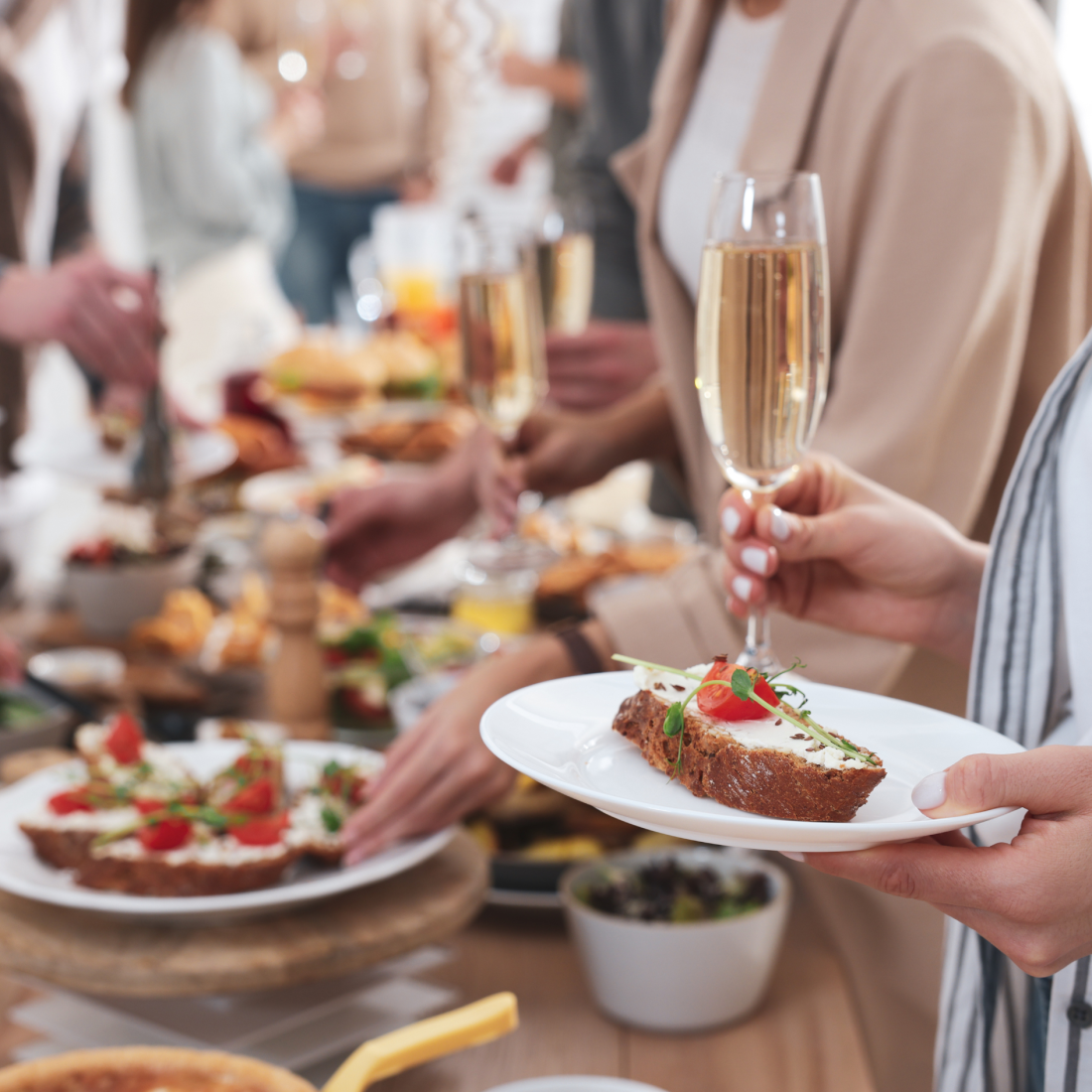 Smartly dressed businesspeople helping themselves to the buffet at a business brunch.