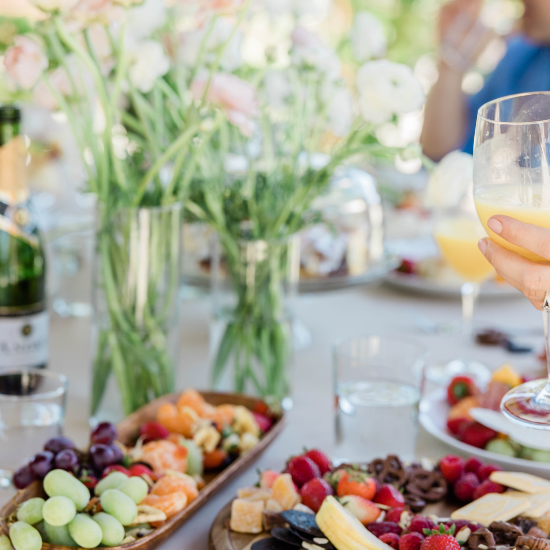 A light. bright buffet table with platters of fresh fruits at a business brunch.