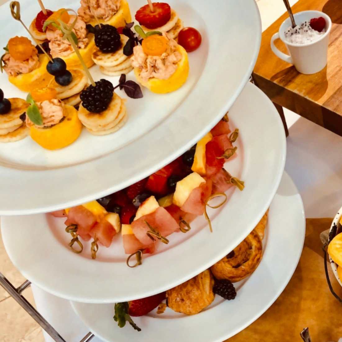 A white cakestand filled with assorted savoury canapes.