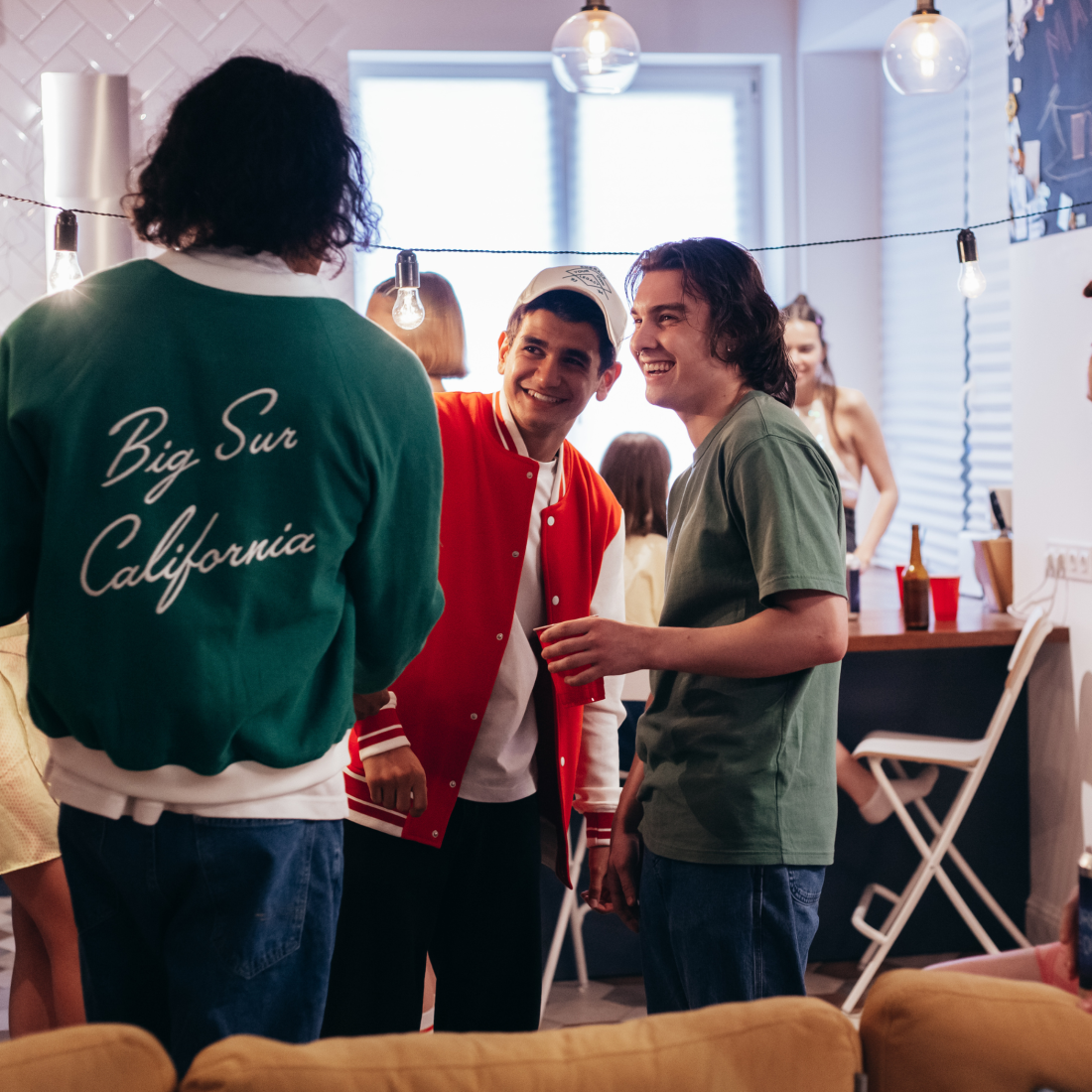 A group of funky young men having a drink at an apres ski themed party.