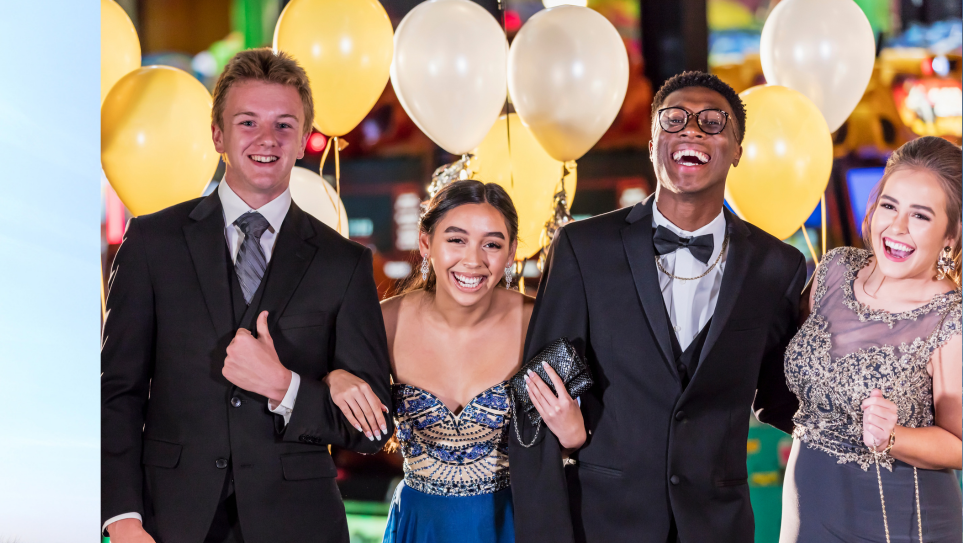 Two dressed up teenage couples at their school prom, linking arms.