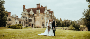 A Bride & Groom stand in front of Balcombe Place