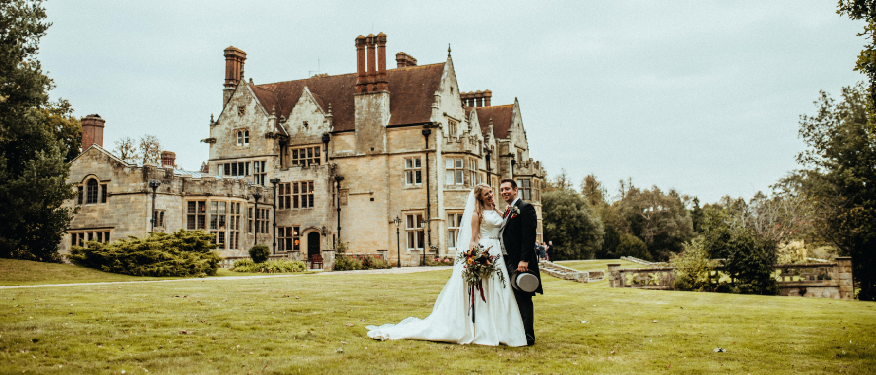 A Bride & Groom stand in front of Balcombe Place