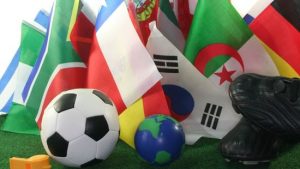 A football surrounded by national flags of World Cups teams