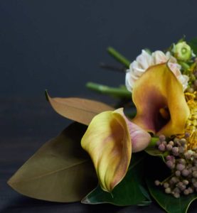 A yellow lily with gypsophilia on a grey wooden slate