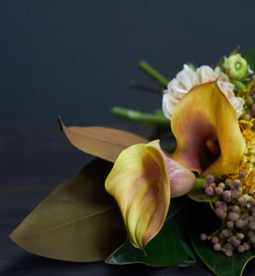 A yellow lily with gypsophilia on a grey wooden slate