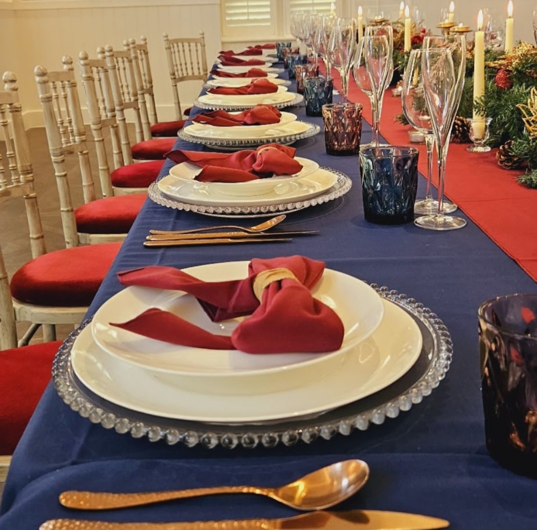 A quirkly red and navy blue themed table setup for a corporate after Christmas party.